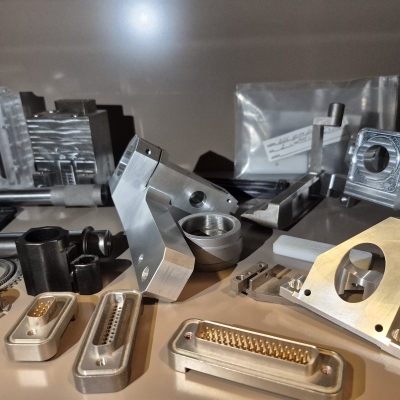 A shelf of varied machined parts at NTM